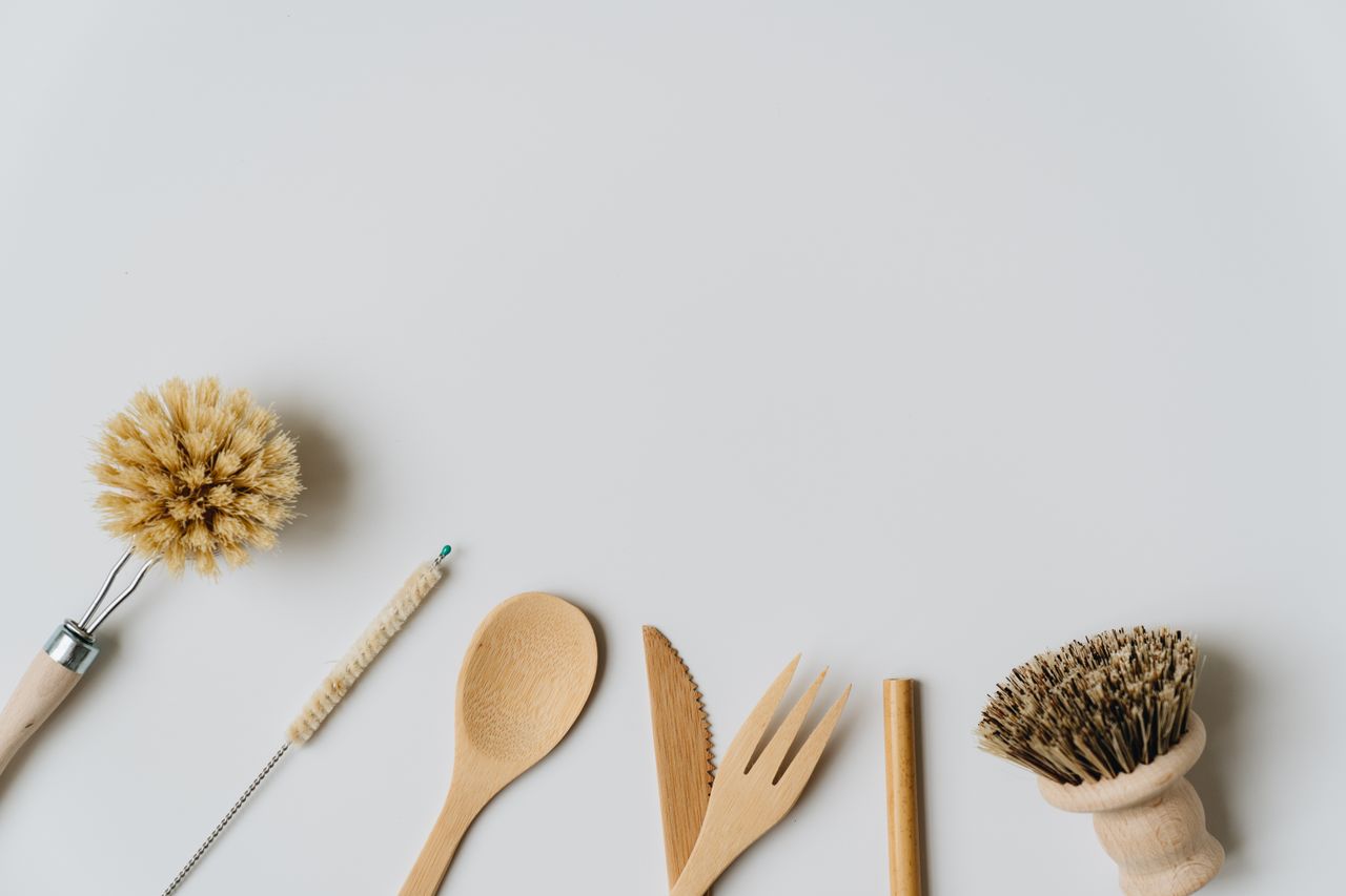 services-03 Ustensiles et brosses de cuisine durables en bois, posés sur un fond blanc, mettant en avant un mode de vie écologique.